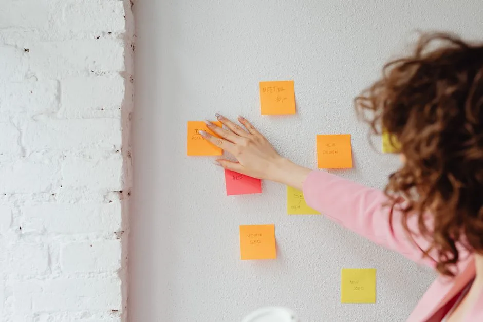 Person organizing colorful sticky notes on a wall
