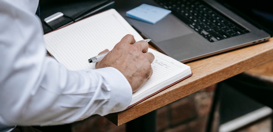 Person writing structured notes at a desk