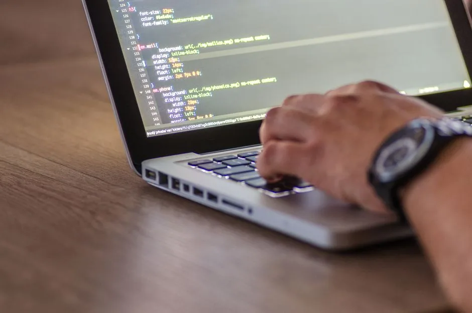 Developer typing code on a laptop